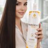 Femme aux cheveux longs et lisses tenant le flacon Lissage Marokino Honey MYA COSMETIC