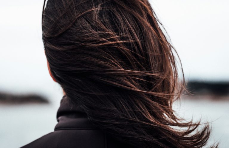 Gros plan de cheveux châtains lisses et brillants en mouvement